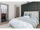 Comfortable bedroom featuring a decorative accent wall, neutral colors, and access to an attached bathroom at 1320 Coral S Way, St Petersburg, FL 33705