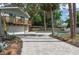 Lush backyard with paved driveway, pool, mature trees, and a house featuring a second story balcony at 1320 Coral S Way, St Petersburg, FL 33705