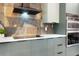 Close up view of kitchen featuring modern cooktop, sleek range hood, and stylish backsplash at 1320 Coral S Way, St Petersburg, FL 33705