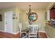 Cozy dining area featuring a glass table, chandelier, and easy access to the kitchen and entrance at 1400 Pine Glen Ln # D2, Tarpon Springs, FL 34688