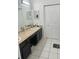 Neutral bathroom with double sinks, dark cabinetry, and tile flooring at 14305 Tennyson Dr, Hudson, FL 34667