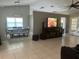 Open-concept living area with dining table, TV, and access to the outdoors through glass doors at 14305 Tennyson Dr, Hudson, FL 34667