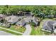 Overhead view of a home with a manicured lawn, mature trees, and a curved driveway leading to the entrance at 16808 Woburn Ln, Lutz, FL 33549