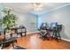 Bedroom with hard wood floors, ceiling fan, and a dedicated desk area with dual monitors at 16808 Woburn Ln, Lutz, FL 33549