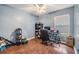 Cozy bedroom features a ceiling fan, hardwood floors and a home office space at 16808 Woburn Ln, Lutz, FL 33549