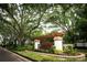 Welcoming community entrance with attractive signage, landscaping, and mature trees at 16808 Woburn Ln, Lutz, FL 33549