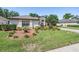 Charming single-story home boasts a well-manicured lawn, mature trees, and a beautiful front garden at 16808 Woburn Ln, Lutz, FL 33549