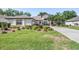 Charming single-story home boasts a well-manicured lawn, mature trees, and a circular driveway at 16808 Woburn Ln, Lutz, FL 33549