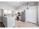 Open kitchen featuring white cabinets, stainless steel appliances, tile floor, and a hanging light fixture at 16808 Woburn Ln, Lutz, FL 33549