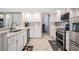 Bright kitchen features white cabinets, stainless appliances, and tile flooring at 16808 Woburn Ln, Lutz, FL 33549