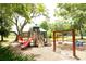 Community playground with slides, swings, and climbing structures, shaded by mature trees at 16808 Woburn Ln, Lutz, FL 33549