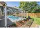 An inviting screened-in pool and patio area with a well-maintained yard and landscaping at 16808 Woburn Ln, Lutz, FL 33549