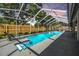 Screened-in pool with an inviting view of the backyard and string lights at 16808 Woburn Ln, Lutz, FL 33549