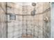Tiled shower area featuring mosaic details, a rainfall showerhead, and sleek design at 16808 Woburn Ln, Lutz, FL 33549