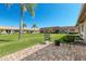 Serene backyard featuring a brick patio, well-maintained lawn, and swaying palm trees at 19029 Us Highway 19 N # 27E, Clearwater, FL 33764