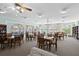 Light-filled community room featuring tables, chairs, bookshelves, and large windows overlooking a patio and the nearby waterway at 19029 Us Highway 19 N # 27E, Clearwater, FL 33764