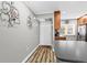 Hallway view with wood floors near kitchen, entryway door, and gray walls at 19029 Us Highway 19 N # 27E, Clearwater, FL 33764
