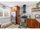 Modern kitchen with stainless steel appliances, wooden cabinets, and a stylish range hood at 19029 Us Highway 19 N # 27E, Clearwater, FL 33764