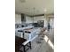 Bright, modern kitchen features white cabinets, stainless steel appliances, an island, and stylish bar stools at 1904 146Th E Ter, Parrish, FL 34219