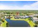 Beautiful aerial view of home with a large pond, screened lanai and lush landscaping at 19230 Wind Dancer St, Lutz, FL 33558