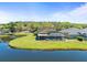 Backyard featuring a screened-in porch overlooking a serene pond and lush green lawn at 19230 Wind Dancer St, Lutz, FL 33558