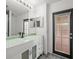 Bathroom featuring modern vanity with black faucet and glass shower doors at 19230 Wind Dancer St, Lutz, FL 33558