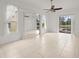 Bright bedroom with tiled floor, mirrored closet, and a sliding glass door to backyard pool at 19230 Wind Dancer St, Lutz, FL 33558