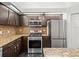 Well-equipped kitchen features stainless appliances, granite countertops and mosaic tile backsplash at 19230 Wind Dancer St, Lutz, FL 33558