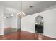Open living area featuring elegant chandeliers and transitions to adjacent rooms with archways at 19230 Wind Dancer St, Lutz, FL 33558