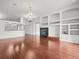 Spacious living room featuring wood floors, a fireplace, built-in shelving, and modern lighting at 19230 Wind Dancer St, Lutz, FL 33558