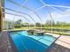 Sparkling screened-in pool with raised hot tub, surrounded by a brick patio and serene views at 19230 Wind Dancer St, Lutz, FL 33558