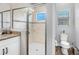 Bright bathroom featuring a glass-enclosed shower, granite countertops, modern fixtures, and a nearby toilet area at 19412 Lonesome Pine Dr, Land O Lakes, FL 34638