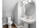 Powder room featuring pedestal sink, round mirror, and modern fixtures at 19412 Lonesome Pine Dr, Land O Lakes, FL 34638