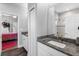 Bright bathroom featuring granite counters, modern fixtures and white cabinetry, complemented by wood-look flooring at 19412 Lonesome Pine Dr, Land O Lakes, FL 34638