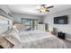 Bright bedroom with a large bed, TV, closet, and balcony access with patio seating at 19412 Lonesome Pine Dr, Land O Lakes, FL 34638