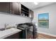 Modern laundry room with new appliances, granite sink, and ample cabinet space at 19412 Lonesome Pine Dr, Land O Lakes, FL 34638