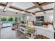 Bright living room with wood-look floors, beamed ceilings, sliding glass doors, and view of the pool at 19412 Lonesome Pine Dr, Land O Lakes, FL 34638