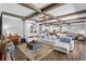 Spacious living room featuring wood-look floors, beamed ceilings, white sofas, and modern decor at 19412 Lonesome Pine Dr, Land O Lakes, FL 34638