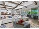 Living area with wood-look floors, beamed ceilings, white sofas, and open layout to the kitchen at 19412 Lonesome Pine Dr, Land O Lakes, FL 34638