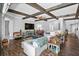 Open-concept living room showcasing wood-look floors, decorative beamed ceilings, and neutral décor at 19412 Lonesome Pine Dr, Land O Lakes, FL 34638