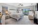 Main bedroom featuring neutral walls, a ceiling fan, plush carpeting, and a large window for natural light at 19412 Lonesome Pine Dr, Land O Lakes, FL 34638