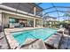 Enjoy outdoor living with a pool and a covered patio with plush seating and a built-in grill at 19412 Lonesome Pine Dr, Land O Lakes, FL 34638