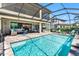 A luxurious screened-in pool area with outdoor kitchen, seating, and beautiful architecture at 19412 Lonesome Pine Dr, Land O Lakes, FL 34638