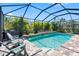 The sparkling pool features a tranquil waterfall, surrounded by ample seating and lush landscaping at 19412 Lonesome Pine Dr, Land O Lakes, FL 34638