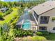 Backyard featuring a screened in pool, large lanai, lush landscaping and mature trees at 19412 Lonesome Pine Dr, Land O Lakes, FL 34638