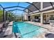 Screened-in pool with waterfalls and lush landscaping offering a serene backyard escape at 19412 Lonesome Pine Dr, Land O Lakes, FL 34638