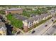 Bird's eye view of the yellow condo building with balconies, landscaping, and nearby commercial areas at 2010 E Palm Ave # 15210, Tampa, FL 33605
