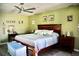 Well-lit bedroom featuring a large bed, ceiling fan, and green-painted walls at 22322 Tennyson Ave, Port Charlotte, FL 33954