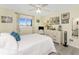 Comfortable bedroom features a large window, light walls, ceiling fan, and white dresser at 22322 Tennyson Ave, Port Charlotte, FL 33954