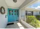 Charming entryway featuring a vibrant blue front door and a welcoming covered porch area at 22322 Tennyson Ave, Port Charlotte, FL 33954